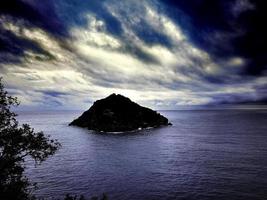 bellissime spiagge di sabbia e ghiaia e un'isola sullo sfondo. acqua di mare con effetto setoso foto