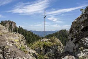 vista su boschi di conifere e montagne rocciose in bulgaria con croce sopra. foto