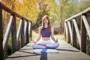 giovane bella donna che fa yoga in natura foto