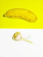 foto minimalista di banana e aglio su sfondo giallo e bianco.
