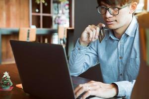 uomo asiatico che utilizza la carta di credito con il concetto di shopping online al bar. foto