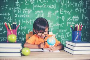 bambino che osserva o studia il modello educativo del globo in classe. foto