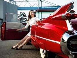 Cadillac rossa d'epoca anni '60 e una bellissima ragazza foto