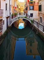 vista turistica di venezia. canali con riflessi. lampioni e case colorate sotto il sole splendente. comodità e tranquillità. foto