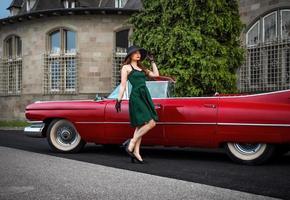 una vecchia cadillac rossa e una bellissima ragazza foto