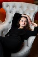 bella ragazza che posa in una poltrona bianca chic foto