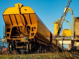 carro merci ferroviario giallo brillante contro il cielo blu nel porto di strasburgo. foto