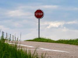 crocevia di strade asfaltate in un pavimento pulito. erba verde e segnaletica stradale foto