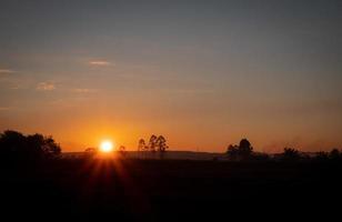 paesaggio di bassa montagna dove il sole mattutino sta sorgendo. la natura limpida del cielo mattutino il sole mattutino è un raggio di luce. foto