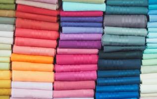 rotoli di tessuto colorato nell'industria del negozio di tessuti. rotoli di tessuto dai colori vivaci foto
