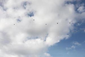 i paracadutisti stanno cadendo sopra le nuvole. paracadutisti nel cielo. un gruppo di paracadutisti che volano nel cielo foto