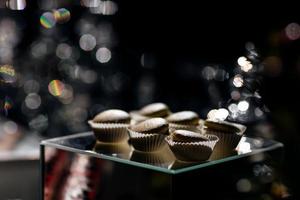 dolci di amaretti al cioccolato su sfondo nero. amaretti su superficie nera foto