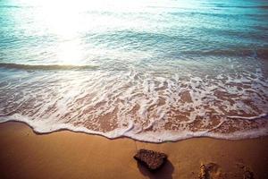 morbide onde blu sulla spiaggia in estate. mare spiaggia cielo blu sabbia sole luce del giorno relax paesaggio punto di vista. il colore dell'acqua e l'acqua limpida e meravigliosamente luminosa.
