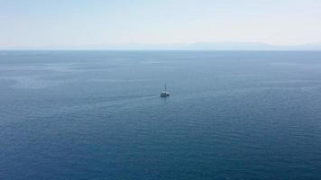 incredibile ripresa aerea in mare aperto con vista su una barca bianca che naviga nel Mar Egeo, in Grecia. foto