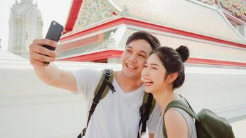 le coppie asiatiche del blogger viaggiano a bangkok, in tailandia, le coppie dolci utilizzando la vista della foto del selfie del telefono cellulare mentre trascorrono del tempo dolce in un viaggio di vacanza al tramonto. le coppie viaggiano nel concetto di città.