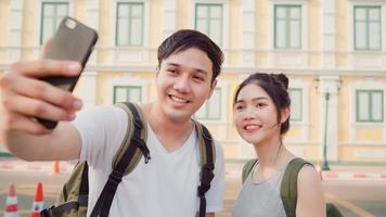 una coppia di blogger asiatici viaggia a Bangkok, in Thailandia, una coppia dolce che usa il telefono cellulare crea vlog e vive sui social media mentre trascorre del tempo dolce durante un viaggio di vacanza. le coppie viaggiano nel concetto di città. foto