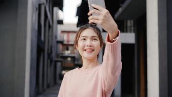 allegra bella giovane donna asiatica blogger viaggiatore con zaino e sacco a pelo che utilizza smartphone prendendo selfie mentre viaggia a chinatown a pechino, cina. concetto di vacanza di viaggio turistico zaino stile di vita. foto