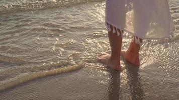 giovane donna asiatica che cammina sulla spiaggia. bella femmina felice rilassarsi camminando sulla spiaggia vicino al mare quando il tramonto in serata. le donne di stile di vita viaggiano sul concetto di spiaggia. foto