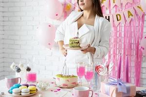 bella donna che celebra la festa di compleanno che tiene un pezzo di torta che fa il desiderio foto