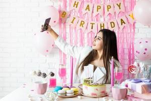 bella donna che celebra la festa di compleanno prendendo selfie foto