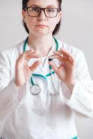 donna medico con le pillole nelle sue mani su uno sfondo bianco. prendendo vitamine o farmaci. copia, spazio vuoto per il testo foto