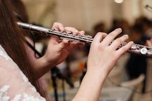 flautista, ragazza che suona il flauto, mani, primo piano delle dita sui tasti, bambini che suonano un flauto traverso laterale, colpo di dettaglio, musica classica, suonatore di strumenti a fiato da vicino astratto foto