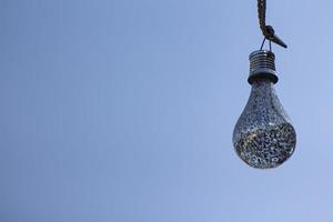 una lampadina contro un cielo blu. chiudi la lampadina. sfondo del cielo blu. lampadina decorativa. foto