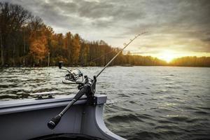 canna da pesca sulla barca. stagione autunnale. canna da pesca sulla barca, ora del tramonto. bei colori autunnali. una canna da pesca è una canna lunga e flessibile usata dai pescatori per catturare i pesci. foto