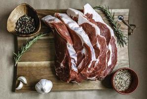 bistecca di costata biologica nutrita con erba su tavola di legno, specie di sfondo di carta. carne di manzo, carne cruda. costata di manzo biologica canadese dal gusto incredibile. ribeye è privo di OGM, steroidi, ormoni e antibiotici foto