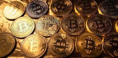 monete d'oro di criptovaluta bitcoin sullo sfondo dorato foto