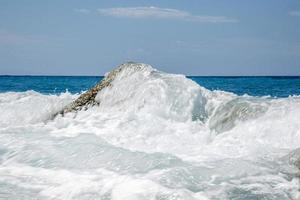 onda alta che si infrange sugli scogli della costa. foto