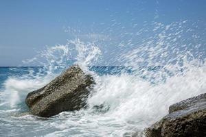 onda alta che si infrange sugli scogli della costa. foto