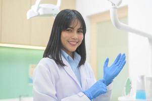 il dentista femminile che indossa guanti medici si prepara a lavorare in una clinica dentale, concetti dentali e assistenza sanitaria.