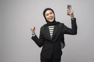 ritratto di bella donna con hijab tramite cellulare su sfondo bianco foto