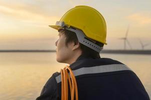un ingegnere maschio che indossa un casco protettivo al tramonto. foto