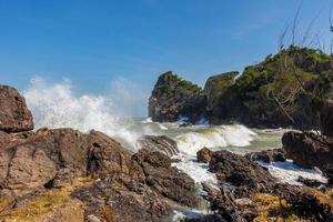 onde e forti venti marini spazzavano le rocce e le secche. onde e brezze marine si infrangono contro rocce e coste. foto