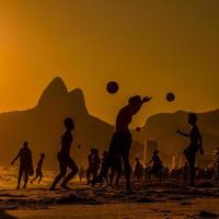 i bagnanti giocano a palla sulla spiaggia di ipenema nella città di rio de janeiro, in brasile. foto