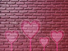 vecchio muro di mattoni cuore di graffiti, sfondo di san valentino foto