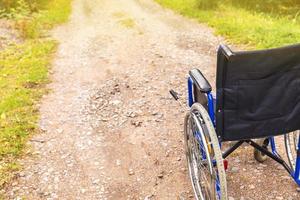 sedia a rotelle vuota in piedi sulla strada in attesa di servizi per i pazienti. sedia a rotelle per persone con disabilità parcheggiate all'aperto. accessibile a persone con disabilità. concetto medico sanitario. foto