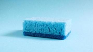 una spugna blu usata per lavare e cancellare lo sporco usato dalle massaie nella vita di tutti i giorni. sono realizzati in materiale poroso come la schiuma. ritenzione del detersivo, che consente di spenderlo in modo economico foto
