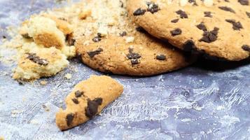 biscotti morbidi con gocce di cioccolato appena sfornati su un piano di lavoro in marmo grigio. pasticceria dolce tradizionale americana, delizioso dessert fatto in casa. sfondo culinario. foto