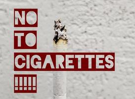 concetto di fumo passivo. in una giornata senza tabacco, fumare è indesiderabile per la società. fumo di sigaretta verticale su uno sfondo bianco con spazio per la copia. sms no alle sigarette. foto