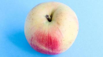 una mela bella, appetitosa e fresca su sfondo blu. concetto di cibo dolce sano. foto