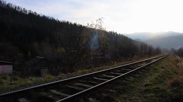 primo piano delle tracce. due binari ferroviari si fondono strettamente. tono vintage. binari e traversine in legno. foto