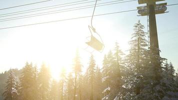 skilift vuoto. sagoma della seggiovia in alta montagna sopra la foresta al tramonto foto