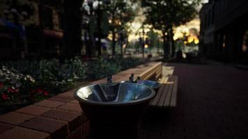 primo piano di una fontana di acqua potabile in un parco al tramonto foto