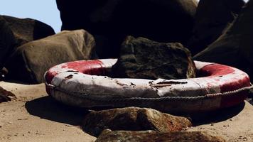 vecchio salvagente sulla spiaggia sabbiosa foto