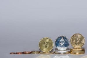 monete in euro e monete crittografiche bitcoin ether e ada in una riga con sfondo grigio dritto foto