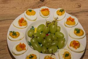 piatto con uova fresche gustose e crema di maionese come l'uva al centro sopra foto