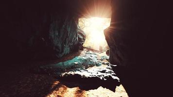 la luce del sole filtra in una grotta di pietra bagnata foto